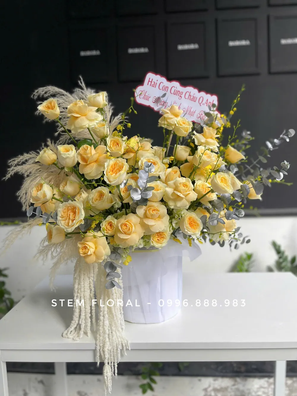 Bình vàng kem thanh nhã — Các bông hoa vàng kem được cắm xòe ngang trong bình trắng có gân