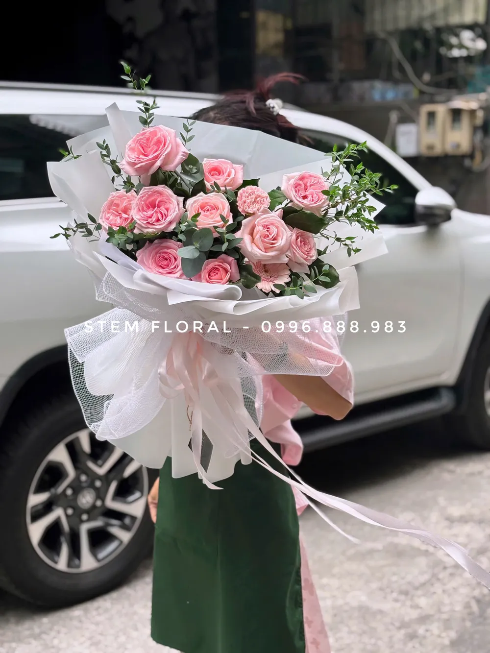 Bó hồng vườn nhỏ — Hoa hồng phấn phối lá xanh đậm và các nhánh nhỏ màu sáng, được bó trong giấy trắng hồng — góc 1