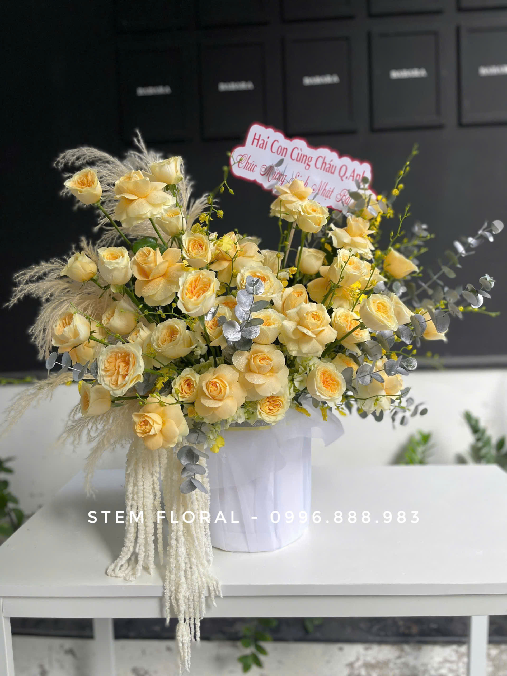 Bình vàng kem thanh nhã — Các bông hoa vàng kem được cắm xòe ngang trong bình trắng có gân
