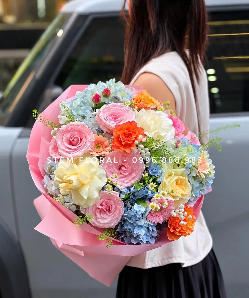 Ngày vui nhiều sắc hoa — Hoa hồng hồng và vàng kem phối cẩm tú cầu xanh, điểm cẩm chướng cam, đồng tiền hồng và nhánh hoa nhỏ trắng