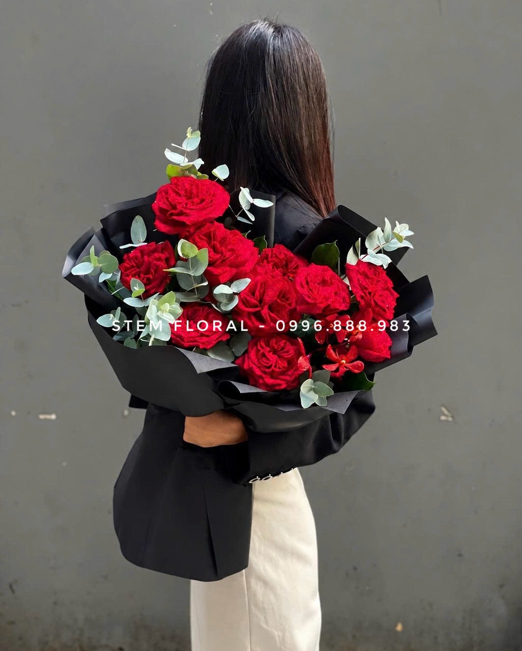 Hồng đỏ cầm tay — Hoa hồng đỏ phối lá xanh trong giấy đen gọn quanh phần cành — góc 1